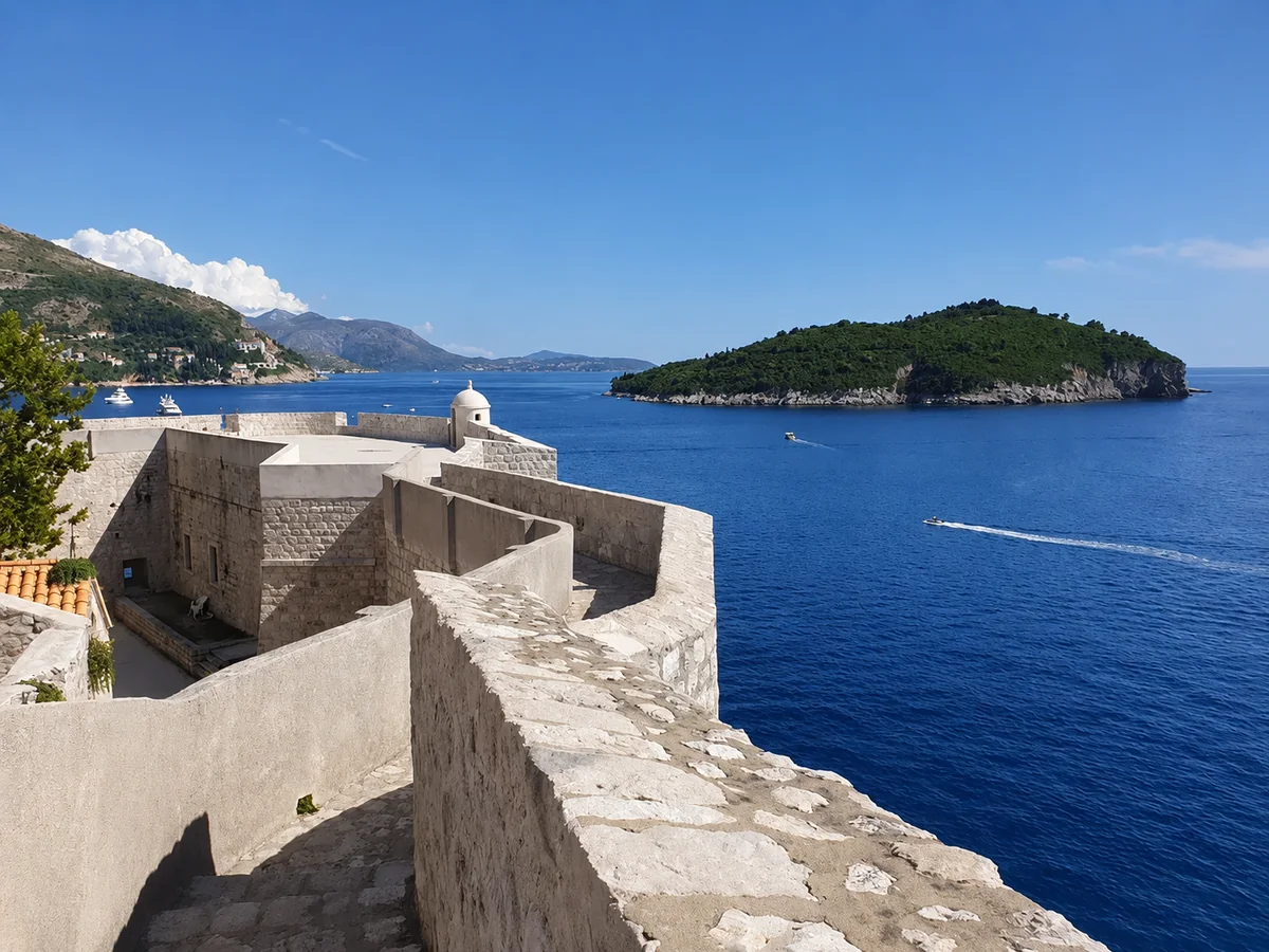 Dubrovnik's city walls dropping to the sea, with Lokrum island across the water
