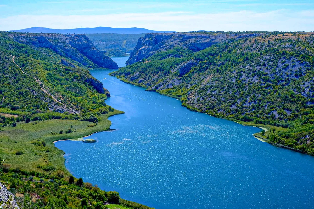 The Krka river winding through its green canyon above the waterfalls