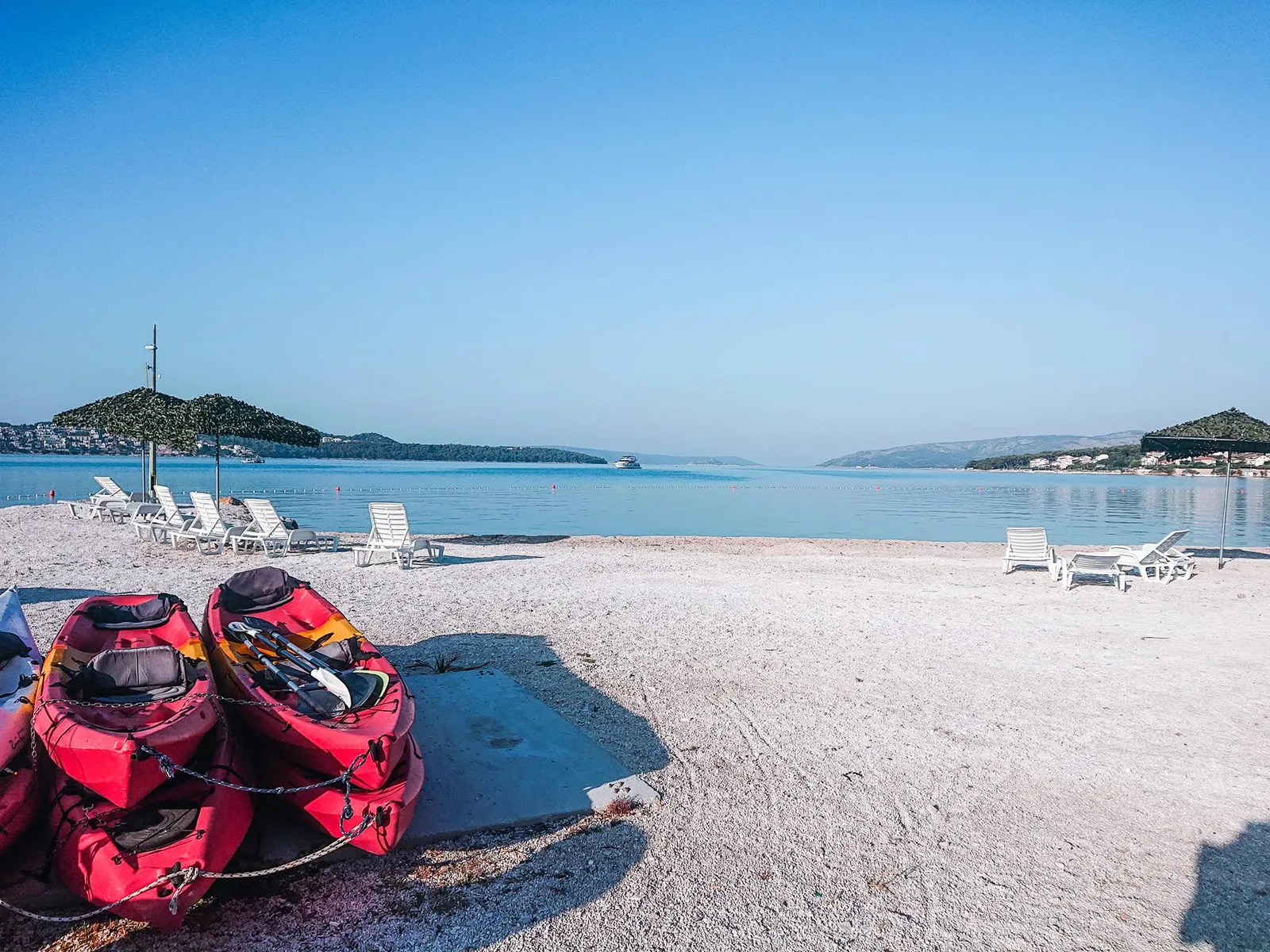 The pebble town beach at Seget Donji with kayaks and clear water