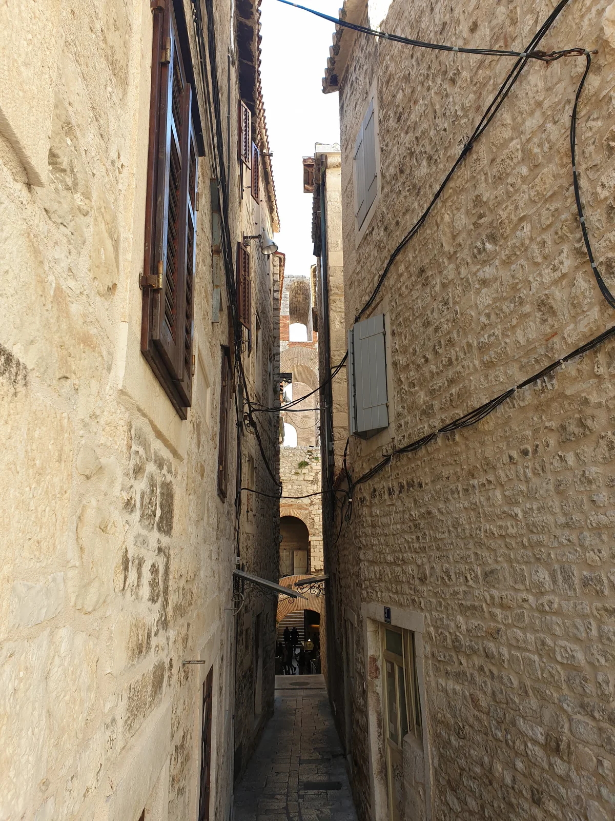 A narrow stone lane between old houses inside Diocletian's Palace