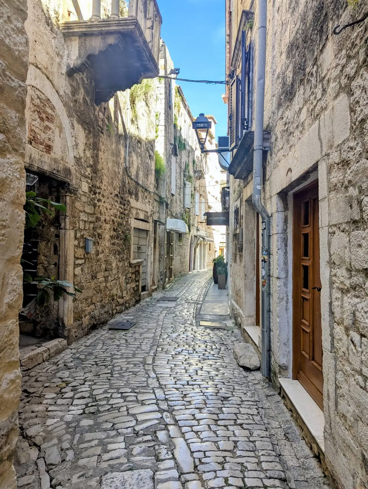 A quiet, narrow stone lane in Trogir's old town
